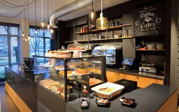 Elegant office space rental at President Kennedylaan 19, The Hague showcasing a cozy pantry with coffee and cakes ready for a break.