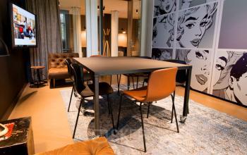 Modern office space rental at President Kennedylaan 19 in The Hague featuring stylish furnishings and vibrant pop art decor.