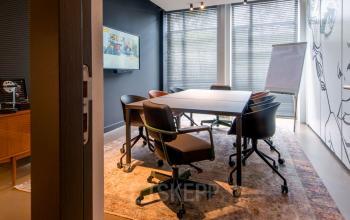 Modern office space rental at President Kennedylaan 19, The Hague, featuring a well-equipped conference room with stylish decor and technology.