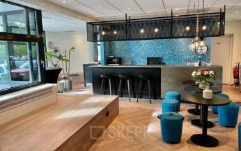 Modern office space for rent in The Hague Statenkwartier, featuring a stylish lounge area with a bar and seating. Ideal for casual meetings and office space rental.
