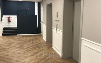 Interior view of an office entrance area at Johan de Wittlaan 3-7, The Hague Statenkwartier, showcasing elevators with a modern floor design. Ideal for office space rental.
