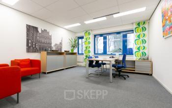 Bright office space at Keulenstraat 12, Deventer, with modern furniture, a desk, chairs, storage cabinets, and colorful wall art.