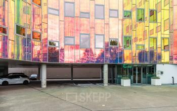 Office building exterior at Zutphenseweg 29, Deventer, ideal for office space rental with vibrant, colorful facade and convenient parking.