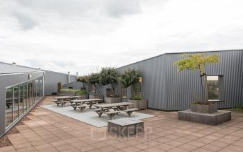 Exterior view of the office space at Zutphenseweg 29, Deventer, featuring outdoor seating suitable for rent office space gatherings.