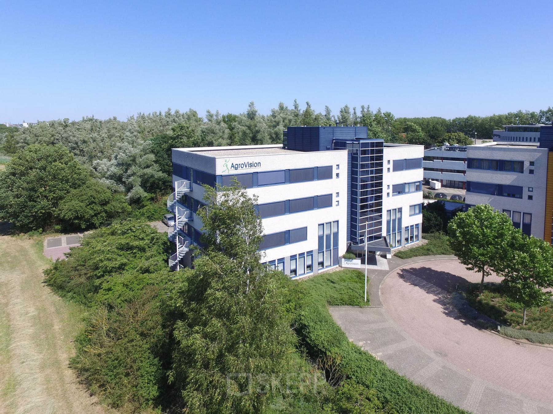 Exterior view of a modern office building at Keulenstraat 15, Deventer, perfect for office space rental, surrounded by greenery.