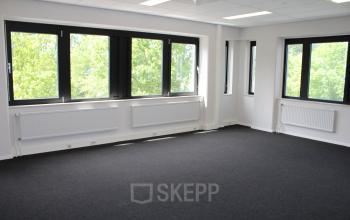 Unfurnished office space with large windows and carpeted floor, ideal for those looking to rent office space in Deventer.