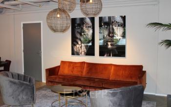Stylish office space for rent at Keulenstraat 1, Deventer, featuring elegant seating with art-adorned walls and modern lighting.