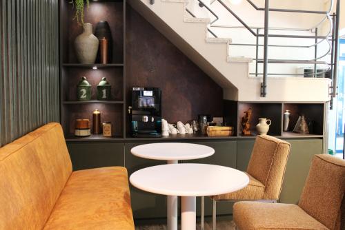 Modern office lounge at Keulenstraat 12 in Deventer, featuring cozy seating and a coffee machine beneath a stylish staircase.