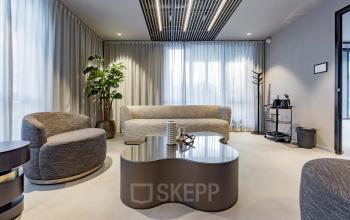 Modern office lounge area at Diemerhof 42, Diemen, featuring stylish furniture and a coffee station, ideal for office space rental.