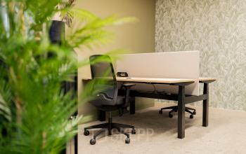 Furnished office space at Diemerhof 42, Diemen, featuring a desk, chairs, and divider in a modern setting, suitable for rent office space needs.