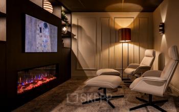 Cozy office lounge space at Diemerhof 42 in Diemen featuring modern chairs, a digital fireplace, and wall lighting. Ideal for relaxation during office space rental.