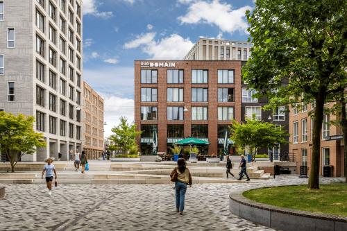 People walking in a modern urban plaza near office buildings at Diemermere 11-19, Diemen. Ideal location for office space rental.