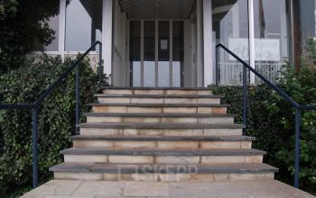 Entrance to the office building at Weesperstraat 118, Diemen with steps leading to glass doors surrounded by greenery.
