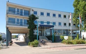 Exterior view of an office building located at Weesperstraat 118 in Diemen, featuring large windows and bikes parked out front.
