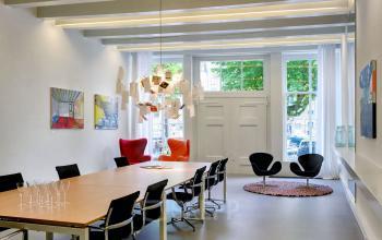 algemene ruimte lunchtafel vergaderruimte loungestoelen schilderijen deur lampen huur kantoorruimte dordrecht haven water