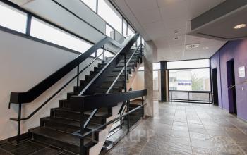 Modern staircase leading to upper floors at Berglaan 4-8, ideal for businesses looking for an office to rent in Drachten.