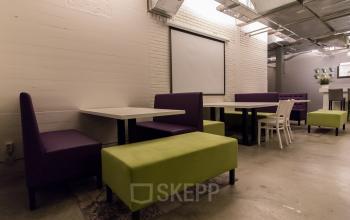 Modern office lounge area with colorful seating arrangements at Berglaan 4-8, Drachten, suitable for casual meetings.