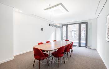 Konferenzraum im Bürogebäude Breite Straße 3, Düsseldorf Altstadt, mit rotem Stuhl-Set und großem Fenster.