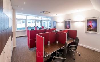 Moderne Bürofläche mit mehreren Arbeitsplätzen und roten Trennwänden zur Miete in der Königsallee 27, Düsseldorf Altstadt.