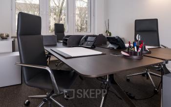 Moderner möblierter Büroraum zur Miete in der Königsallee 27, Düsseldorf Altstadt. Elegante Ausstattung mit Schreibtischen und Bürostühlen, ideal für produktive Arbeitssitzungen.