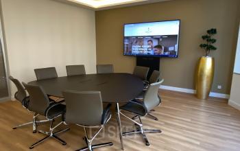 Konferenzraum zur Miete in Düsseldorf Altstadt, Königsallee 27, mit modernem Tisch, acht Stühlen und großem Bildschirm für Präsentationen.