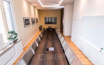 Moderner Konferenzraum zur Büromiete in der Königsallee 27, Düsseldorf Altstadt, mit langem Tisch, bequemen Stühlen und großer Präsentationsfläche.