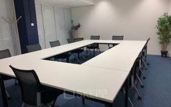 Modern conference room available for office space rental at Galvanistraat 1, Ede with a large table, chairs, and plants.