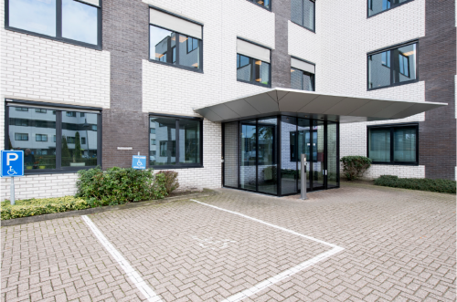 Entrance to an office building at Galvanistraat 7, Ede, featuring an accessible entrance and parking spaces. Ideal for office space rental.