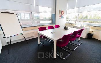 Office space rental at Flight Forum 40, Eindhoven Airport, featuring a modern meeting area with a conference table and chairs.