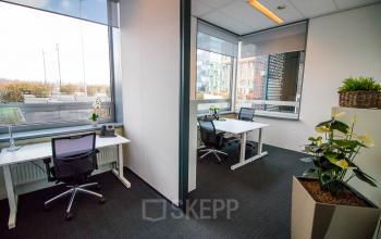 Bright office space rental at Flight Forum 40, Eindhoven Airport, featuring modern desks and chairs with natural light streaming through large windows.