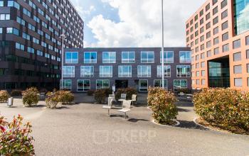 Exterior view of office building at Flight Forum 40, Eindhoven Airport. Ideal for office space rental with modern architecture and outdoor seating.