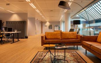 Spacious and modern office interior at Flight Forum 760-780, Eindhoven Airport, featuring stylish furniture and warm lighting, perfect for creative collaboration. Ideal for office space rental, fostering productivity and comfort.