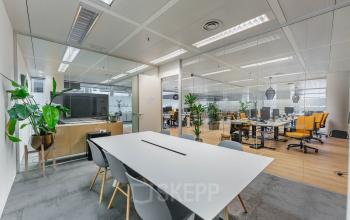 Modern office interior at Flight Forum 760-780, Eindhoven Airport. Features a sleek conference room with a large white table and ergonomic chairs, perfect for office space rental.