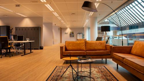 Spacious and modern office interior at Flight Forum 760-780, Eindhoven Airport, featuring stylish furniture and warm lighting, perfect for creative collaboration. Ideal for office space rental, fostering productivity and comfort.