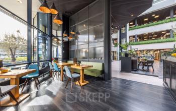 Modern furnished office space at Eindhoven Airport with stylish seating and ample natural light, perfect for rent office space enthusiasts seeking a vibrant workspace environment.