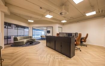 Modern office space at Luchthavenweg 81, Eindhoven Airport, featuring sleek desks and a curved couch, perfect for office space rental.