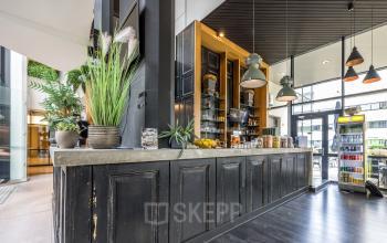 Stylish office space to rent at Luchthavenweg 81, Eindhoven Airport, featuring a chic reception area with elegant wooden paneling and modern lighting.