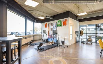 Modern and bright office space for rent at Luchthavenweg 81, Eindhoven Airport, featuring exercise equipment and stylish decor.