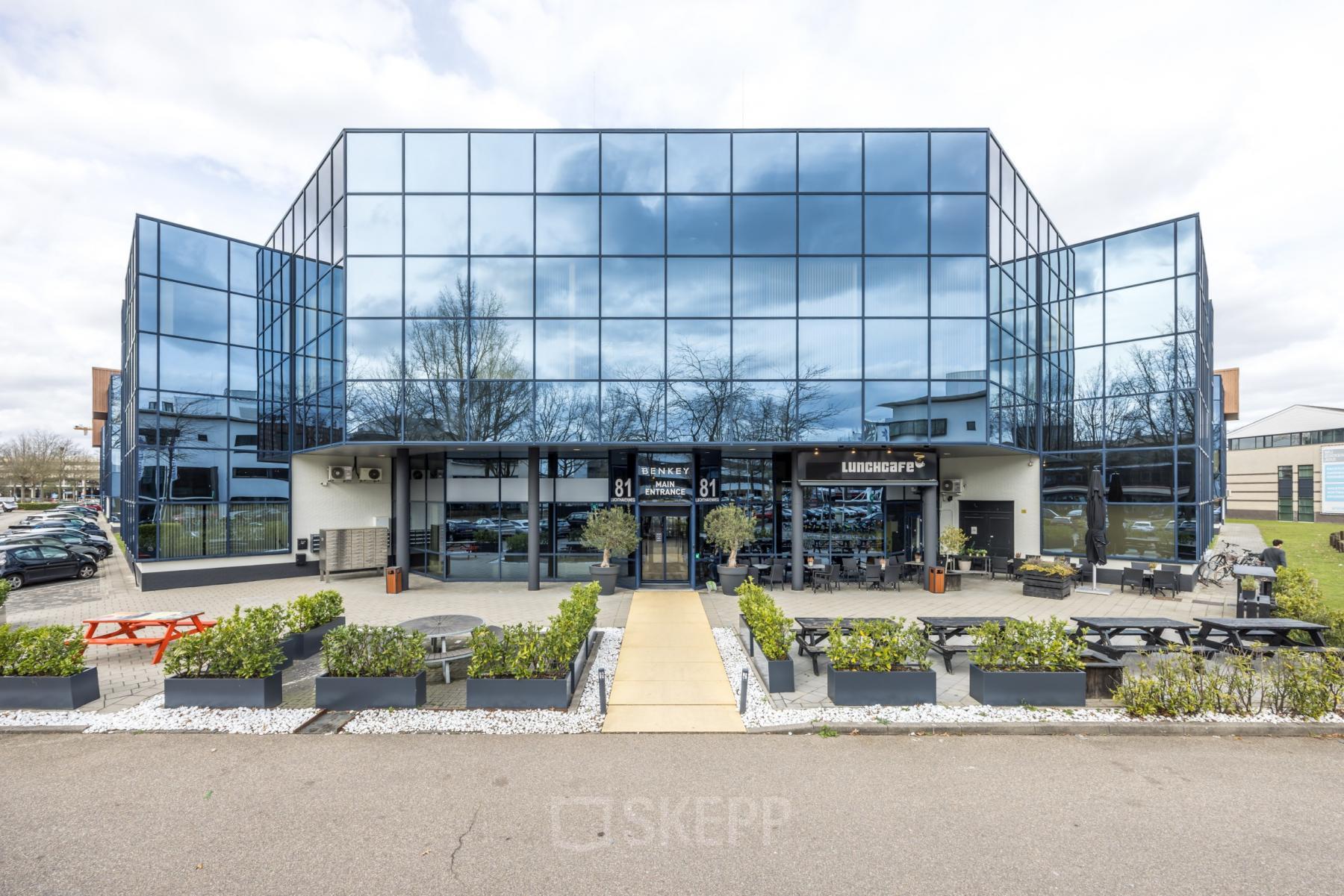 Modern office building at Luchthavenweg 81 with sleek glass facade, ideal for office space rental at Eindhoven Airport.