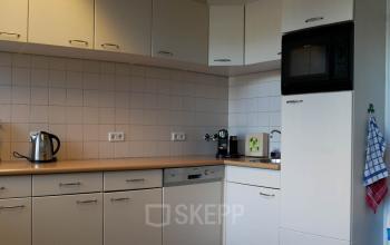 Office pantry area at Luchthavenweg 55, Eindhoven Airport, equipped with appliances and cabinets for office space rental.