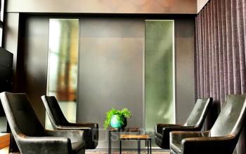 Elegant lounge area with modern armchairs and a large chandelier at Luchthavenweg 55, Eindhoven Airport, ideal for office space rental.