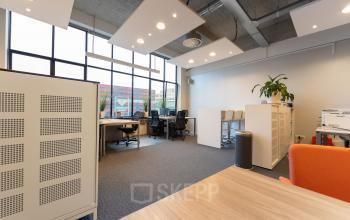 Bright office space at Lichttoren 32, Eindhoven Center with desks and chairs available for rent, under high ceilings and large windows. Ideal for office space rental.