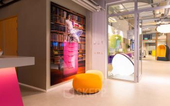 A vibrant office space to rent at Lichttoren 32, Eindhoven Center, featuring colorful seating and modern decor. Ideal for creative workspaces.
