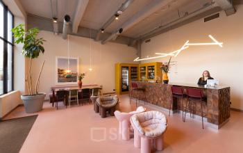 Stylish office space for rent at Lichttoren 32, Eindhoven Center, featuring modern furniture and a welcoming atmosphere with a person at the reception desk.