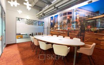 Modern office space for rent at Lichttoren 32, Eindhoven Center, featuring a stylish conference room with a large table and comfortable chairs.
