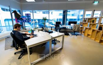 Comfortable office space rental at Bogert 1, Eindhoven Center, with a person focused on business tasks at a clean workstation amidst modern decor.