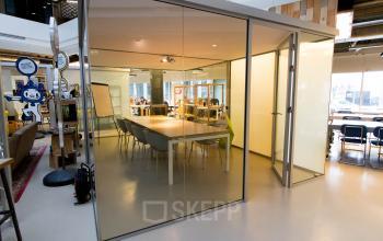 Modern office space rental at Bogert 1, Eindhoven Center with a glass-walled meeting room and well-lit workspaces.