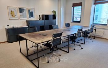 Modern conference room at Emmasingel 33, Eindhoven Center, featuring a sleek table surrounded by ergonomic chairs, ideal for meetings or office space rental needs.