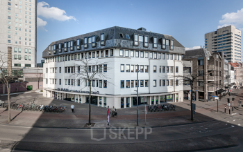 Exterior view of the office building at Emmasingel 33 in Eindhoven Center, suitable for office space rental, with its distinct geometric roof and large windows.