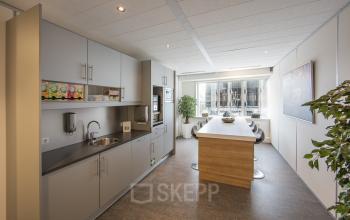 Modern office space rental at Fellenoord 130, Eindhoven Center, featuring a well-equipped kitchen and a bright, inviting dining area.